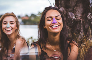 Two girls wearing noz zinc oxide sunscreen laughing together outside  